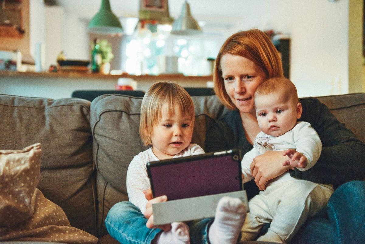 A mom on the couch with two little ones