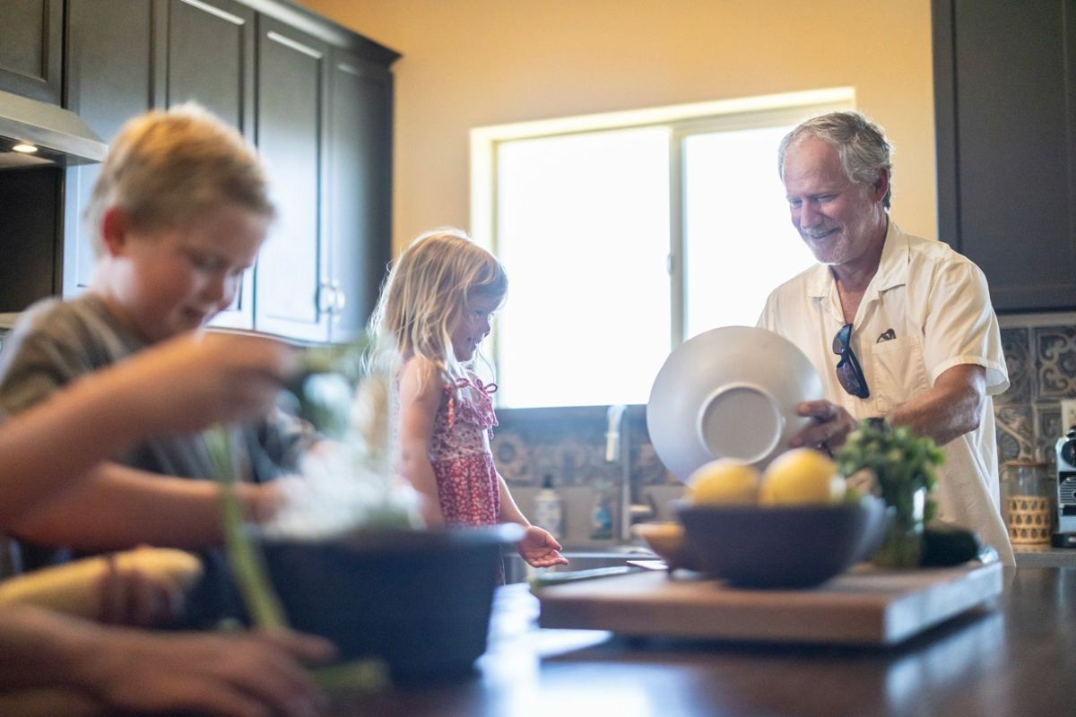A grandfather cooking breakfast with the kids